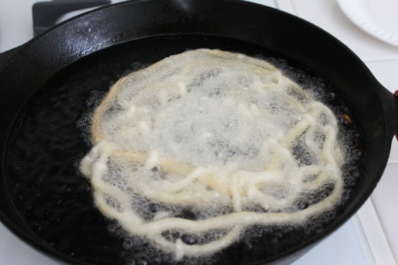 squeeze pancake batter out of bottle into hot oil to create funnel ...