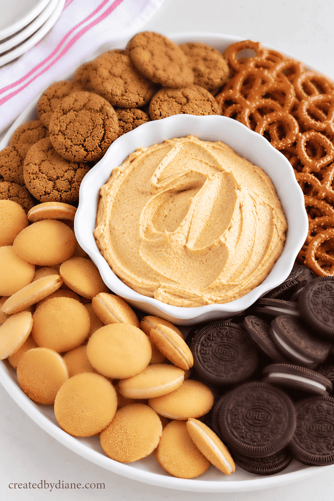 pumpkin dip recipe a sweet creamy fall pumpkin spice dip great for halloween parties, vanilla and chocolate cookies pretzels and ginger snaps and apples.