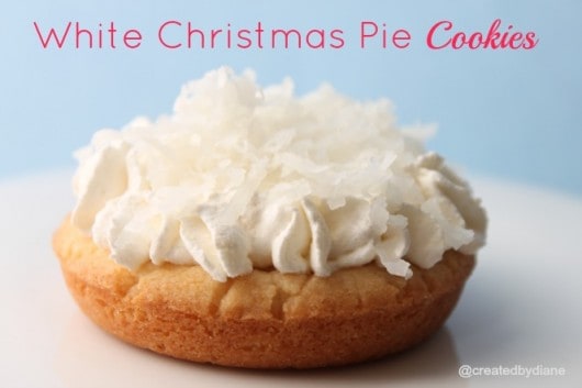single White Christmas Pie Cookie with frosting and coconut flakes on a white plate with blue background
