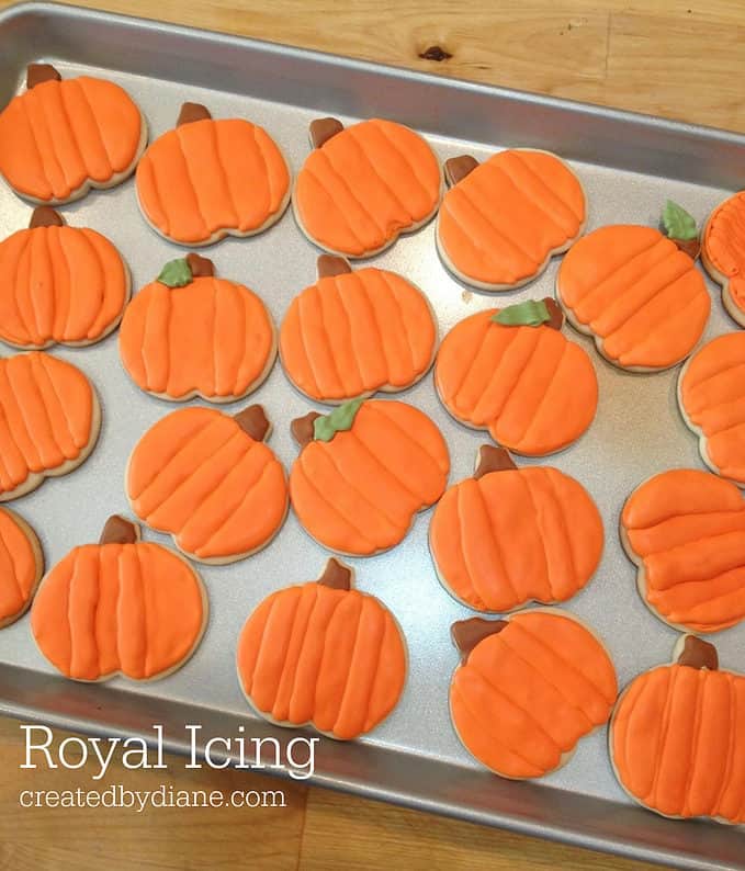 orange royal icing on pumpkin shaped cookies great for halloween and Thanksgiving createdbydiane.com