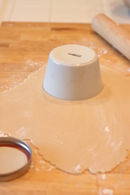 cutting pie crust with a bowl