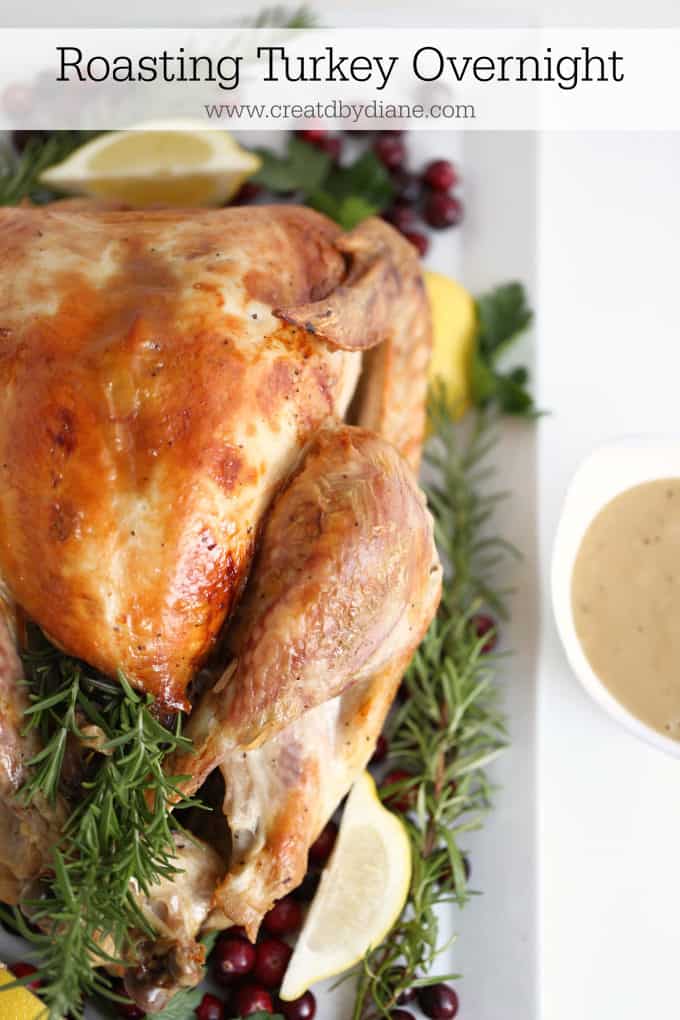 Young woman measuring temperature of whole roasted turkey with meat  thermometer Stock Photo