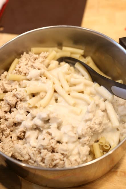 mixing chicken baked ziti