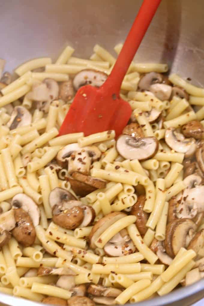 mixing sauce with pasta for mushroom baked ziti