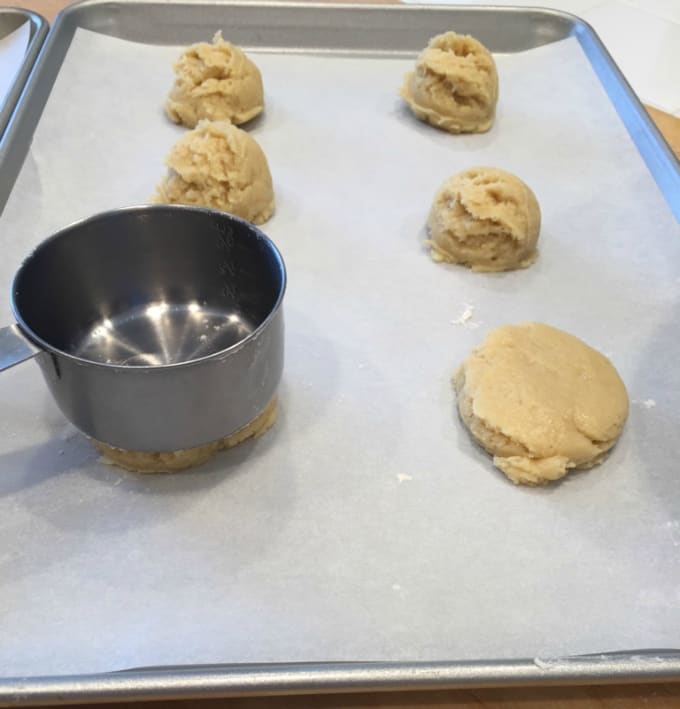 pressing cookies with a measuring cup