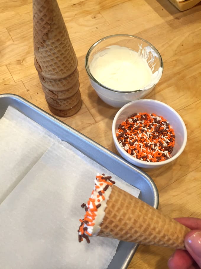 putting melted chocolate on cones