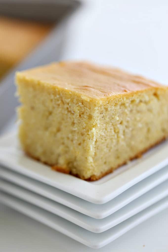 cornbread cut into a square on a stack of white plates