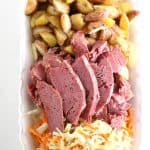 sliced slow cooked corned beef with roasted potatoes and sautéed cabbage