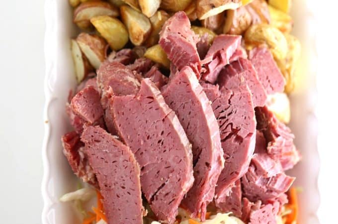 sliced slow cooked corned beef with roasted potatoes and sautéed cabbage
