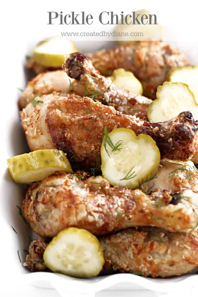 sliced pickles with dill on crispy chicken legs in a white dish