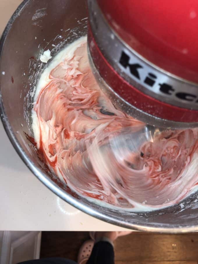 whipping strawberry frosting with a mixer, pretty pink color