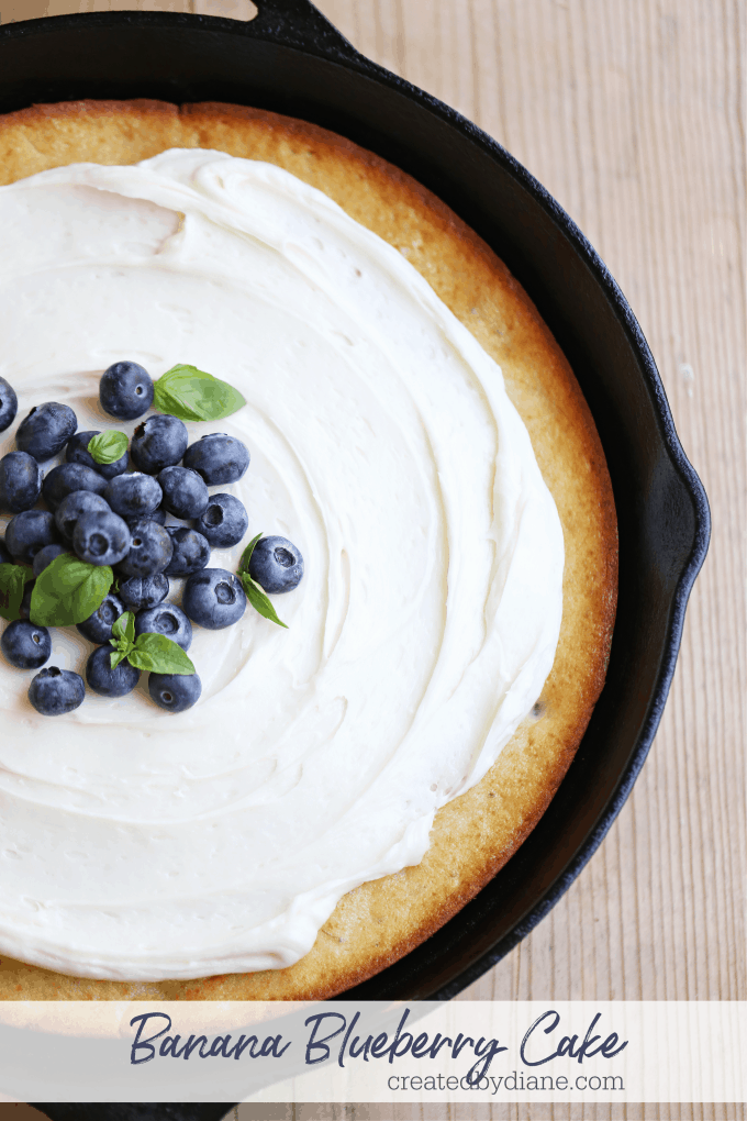 Banana Blueberry Cake in a skillet topped with cream cheese frosting createdbydiane.com