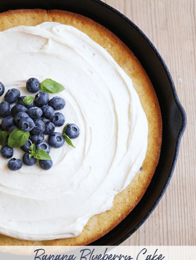 Banana Blueberry Cake in a skillet topped with cream cheese frosting createdbydiane.com