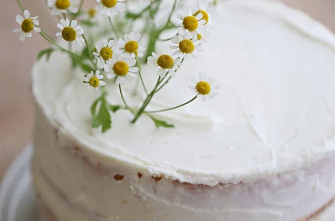 2 layer white cake,easy and delicous super great shortcut recipe, decorated with camomile flowers, naked cake, sour cream frosting slathered on edges and topcreatedbydiane.com