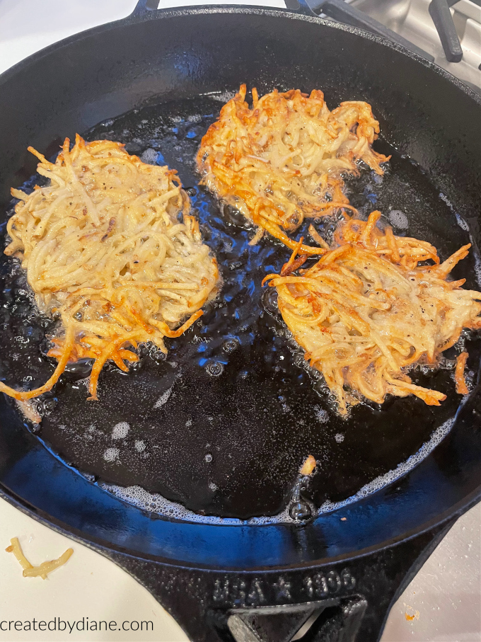 cooking potato pancakes:latkes in oil with cast iron skillet