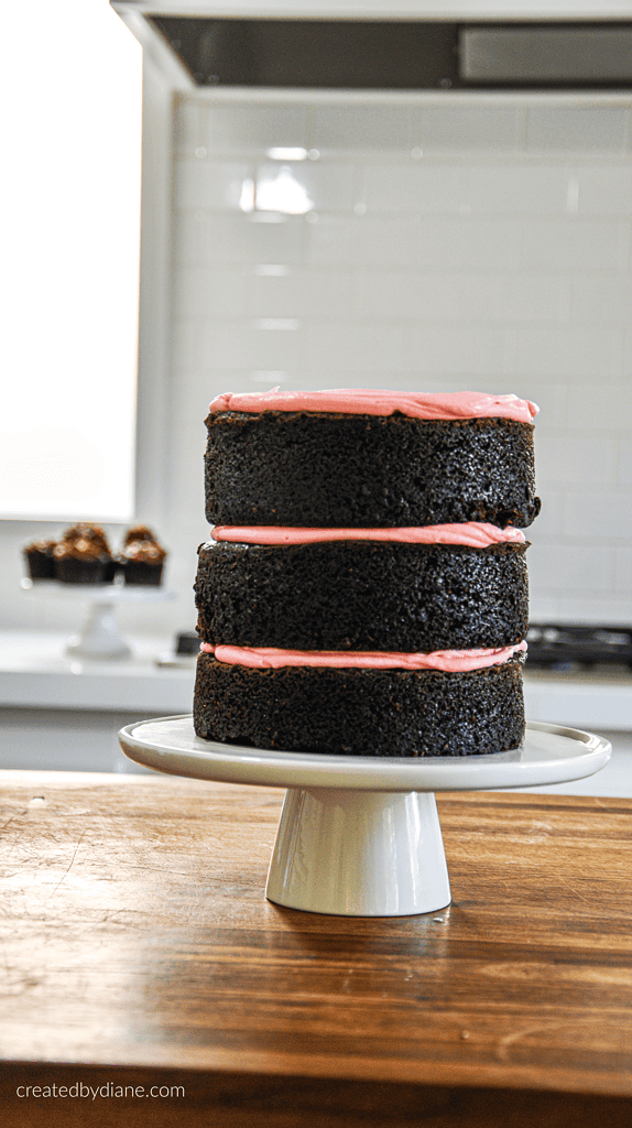 3 layer pink cake in white kitchen on walnut chopping black createdbydiane.com