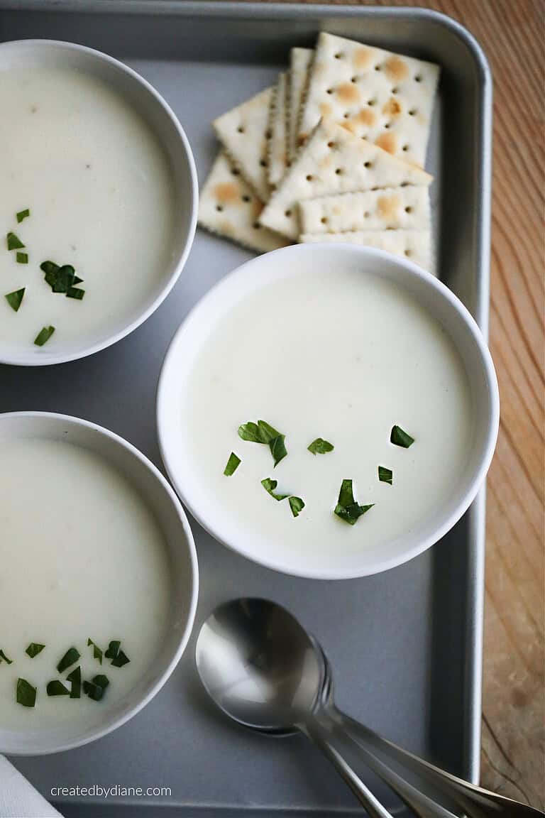 traditional Irish potato soup recipe from createdbydiane, on a try with crackers teh soup is in white bowls with parsley on top