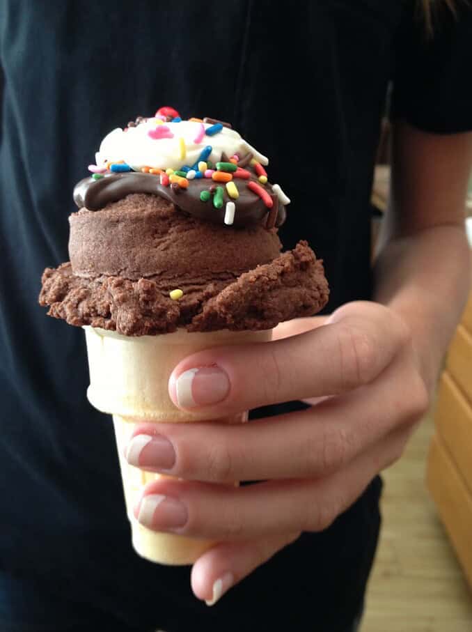 ice cream cone cookies, on a cone, topped with hot fudge and frosting, and sprinkles